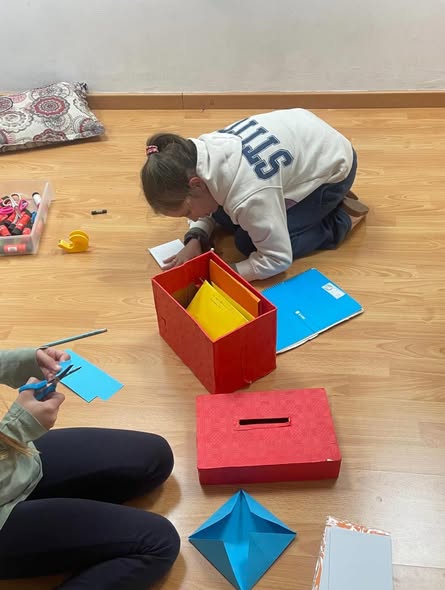 Alumna trabajando con cajas y manualidades en clase