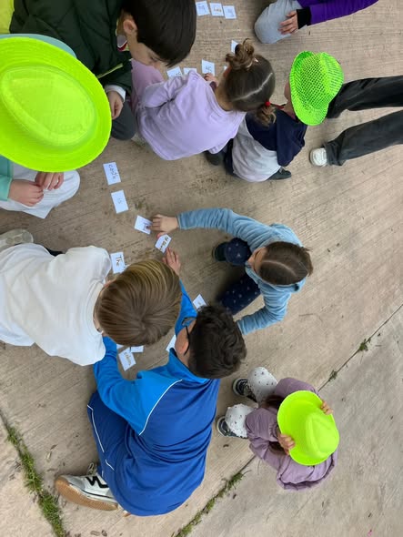 Grupo de niños jugando con tarjetas de vocabulario al aire libre